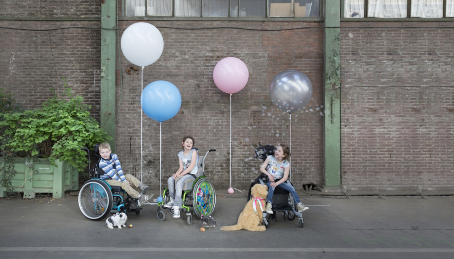 Drie kinderen in rolstoel met ballonnen