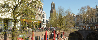 terras aan water in utrecht met dom op achtergrond