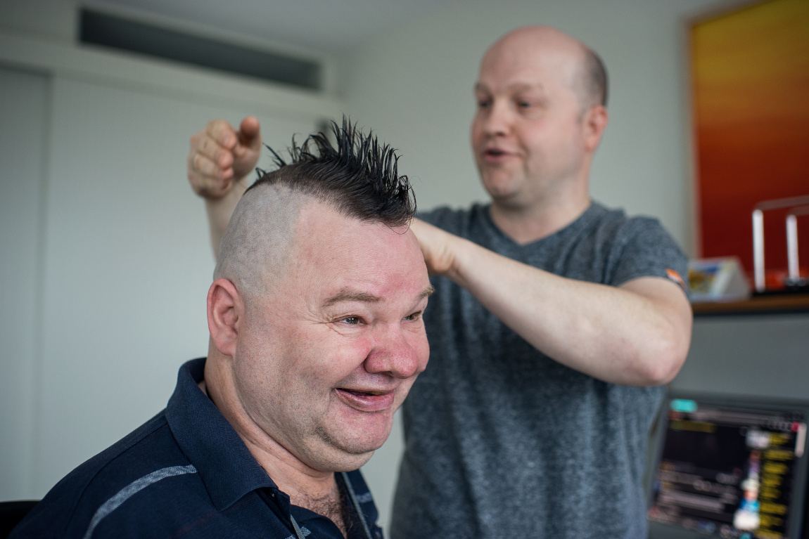 Man brengt het haar van andere man in model