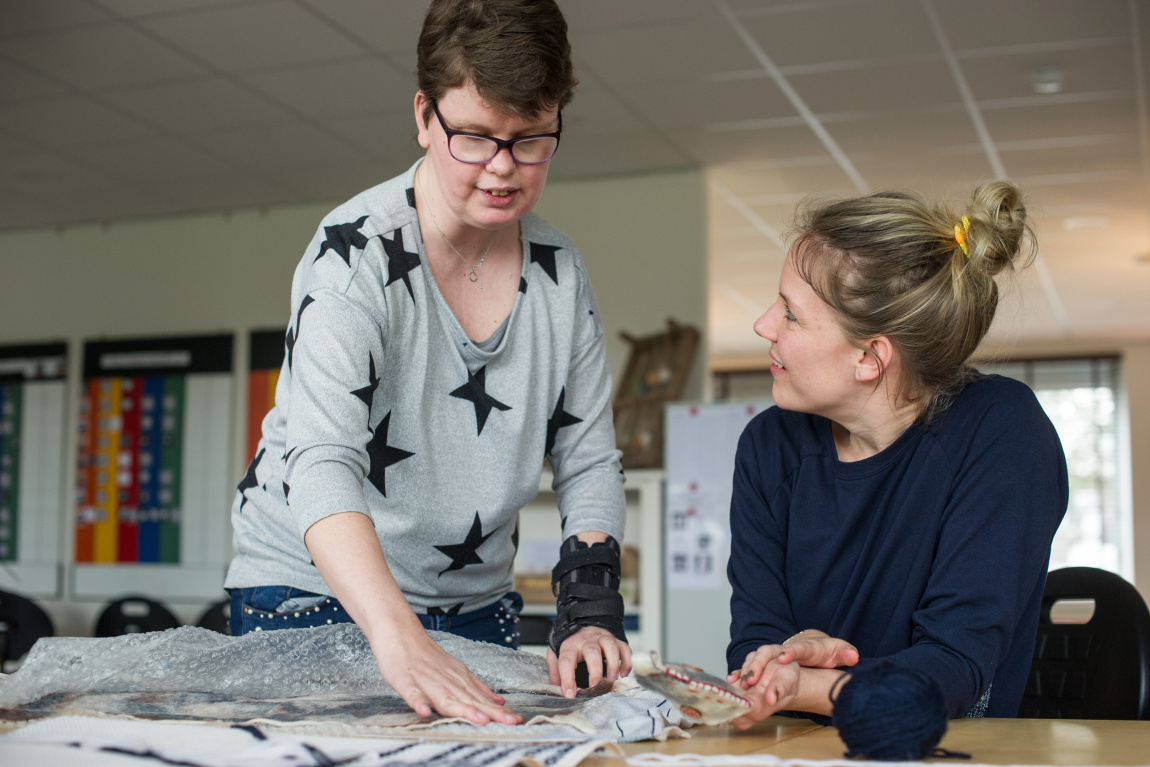 Vrouw laat doek zien aan andere vrouw