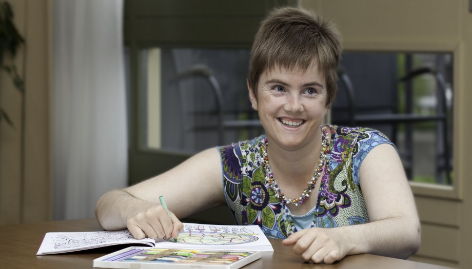 Vrouw die blij is en aan het kleuren