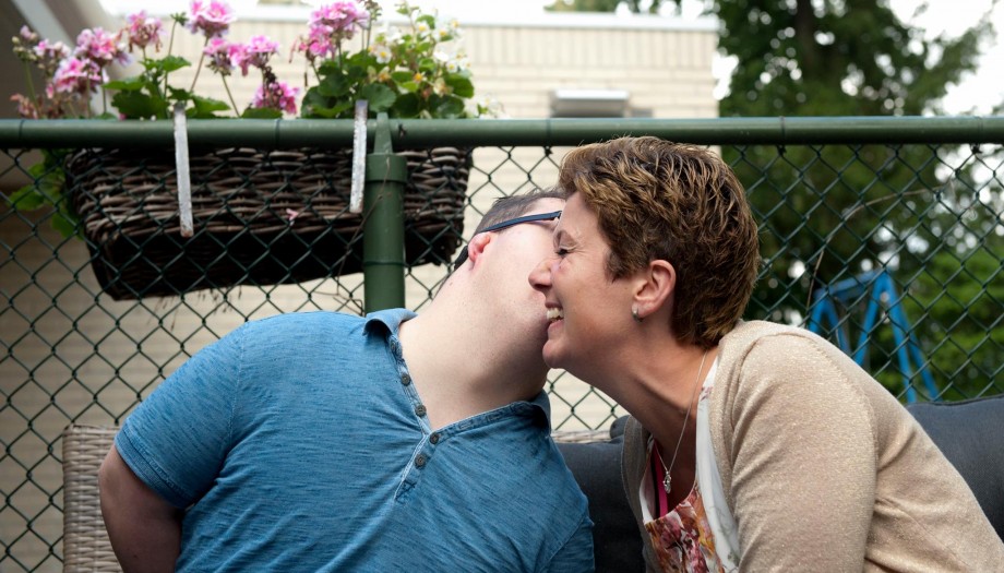 Man fluistert in oor van lachende vrouw