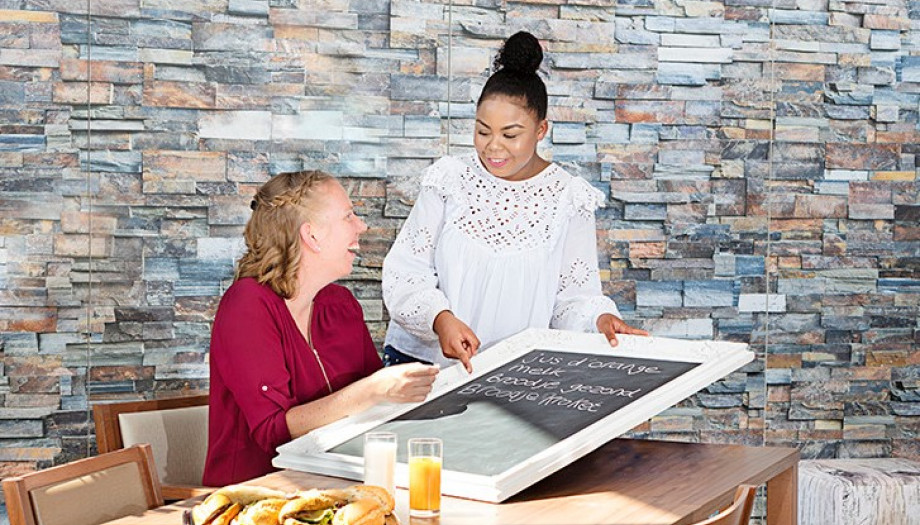 Twee vrolijke mensen in gesprek met eten erbij