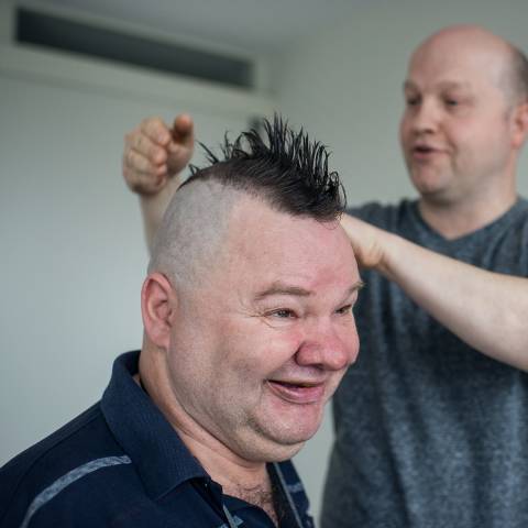 Man brengt het haar van andere man in model