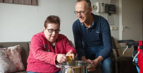 Vrouw schilt aardappels, man kijkt toe