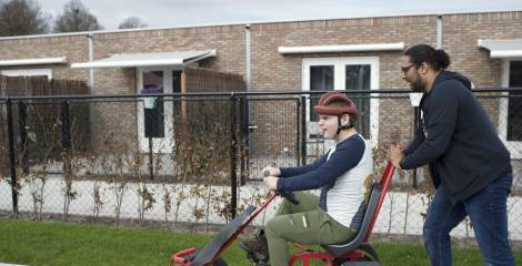 Begeleider duwt jongen op skelter