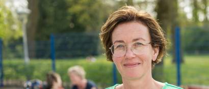 Vrouw op voorgrond met op de achtergrond verschillende personen